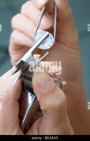 A jeweler using a diamond gauge on a diamond Stock Photo