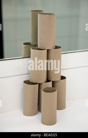 A pyramid shaped stack of empty toilet paper rolls Stock Photo