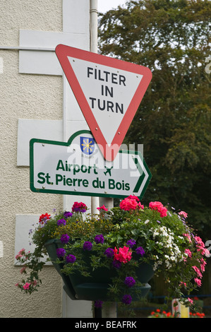 dh  ST MARTIN GUERNSEY Guernsey traffic junction filter in turn sign with flowers signpost road channel islands Stock Photo
