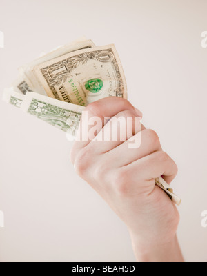 Woman gripping dollar bills Stock Photo