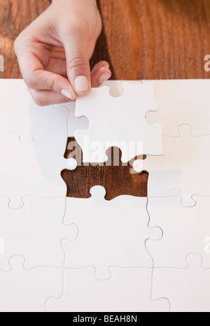 Woman completing jigsaw puzzle Stock Photo