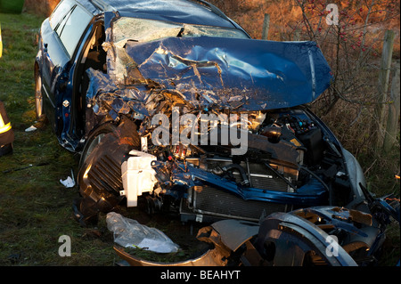 crashed car in ditch on country lane Stock Photo