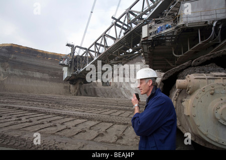 Worker talking on radio near a bucket-wheel excavator, Grevenbroich, Germany Stock Photo