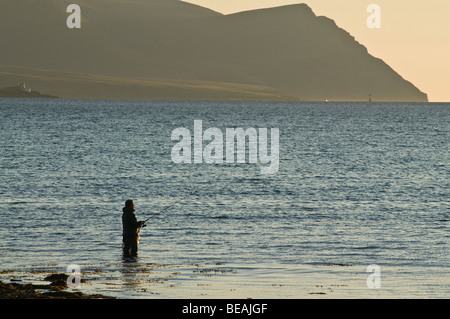dh Angler rod fishing SCAPA FLOW ORKNEY Wading fisherman off shore evening Hoy hills Stock Photo