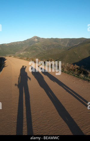 three long shadows on the walking path up to Las Medulas viewpoint spain castile and leon Stock Photo