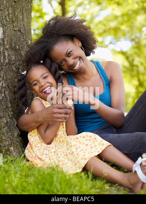 African mother and daughter hugging in park Stock Photo