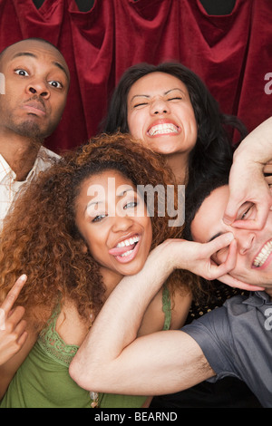 Friends making silly faces in photo booth Stock Photo