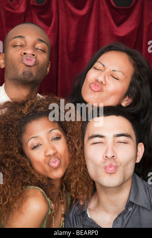 Friends puckering lips in photo booth Stock Photo