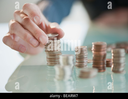 Close up of Hispanic woman stacking coins Stock Photo