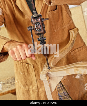 detail of caucasian carpenter at work with old vintage manual drill Stock Photo