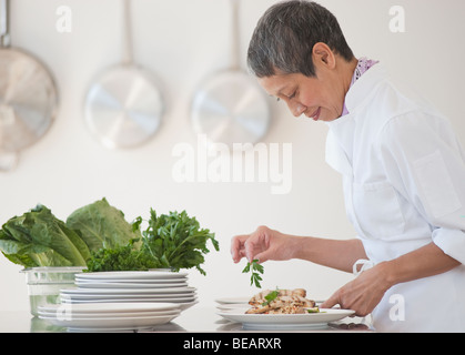 Chinese chef plating meals in professional kitchen Stock Photo