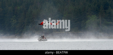 'A Coast Guard Helicopter patrol practices basket lowering on the inland waterways of Alaska.' Stock Photo
