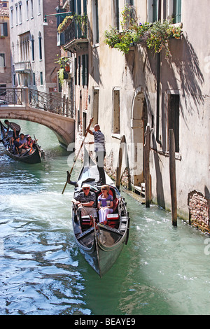 Tourists to Venice enjoy a ride in a Gondolier through the canals and water ways ,Italy Stock Photo