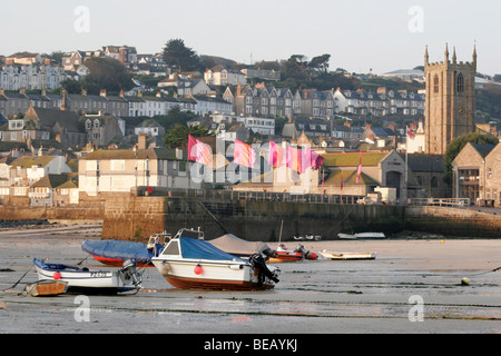 The Harbour at St Ives in Cornwall at low tide with the flags flying in the distance for the annual arts festival Stock Photo