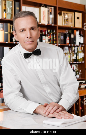 Waiter leaning against a bar counter Stock Photo