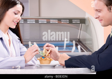 Couple eating ice cream in an ice cream parlor Stock Photo