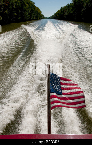 Windblown US flag in powerboats wake. Stock Photo