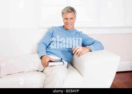 Man reclining on a couch Stock Photo