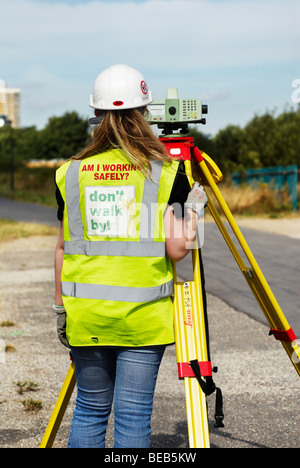 Construction site engineer using a theodolite on the Olympic Stadium site Stratford East London UK Stock Photo