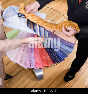 Saleswoman assisting a businessman in a clothing store Stock Photo