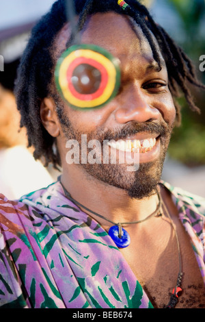 Portrait of a young man smiling with a necklace over his eye Stock Photo