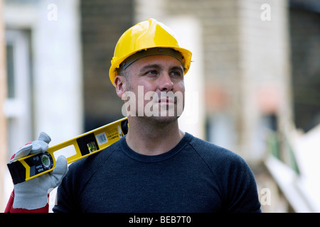 Builder in front of a house being renovated Stock Photo