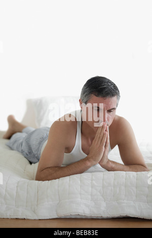 Man lying on the bed and thinking Stock Photo