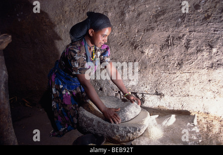 Woman grinding teff seeds into a flour,   Ethiopia, Africa Stock Photo