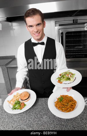 Waiter holding plates of foods Stock Photo