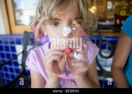 Girl blowing bubbles with a bubble wand Stock Photo