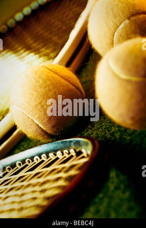 Close-up of three tennis balls with two tennis rackets in a court Stock Photo