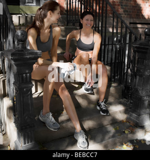 Two women sitting on steps and smiling Stock Photo