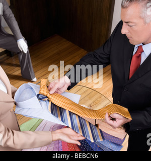 Saleswoman assisting a businessman in a clothing store Stock Photo
