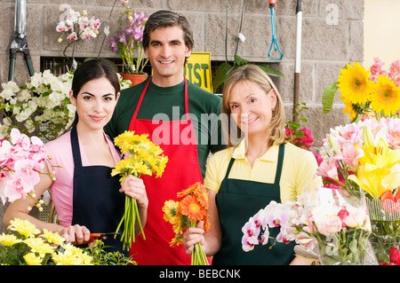 Two female florists with a male florist smiling Stock Photo