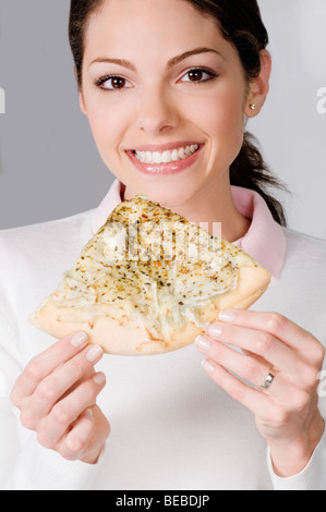 Female chef holding a slice of pizza Stock Photo