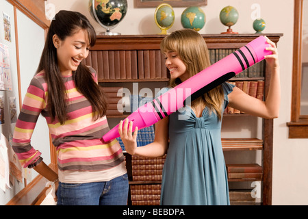 Two students playing in a school library Stock Photo