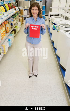 Sales clerk showing Special Offer sign in a supermarket Stock Photo