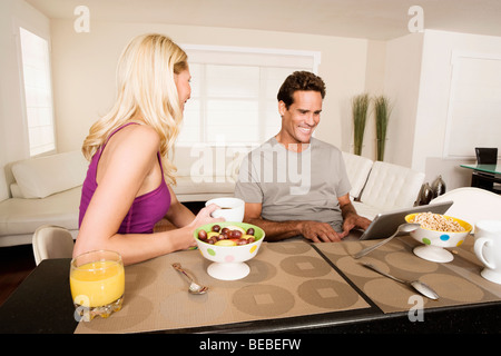Couple having breakfast and using a laptop Stock Photo