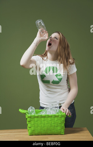 Thirsty woman trying to drink water from an empty water bottle Stock Photo