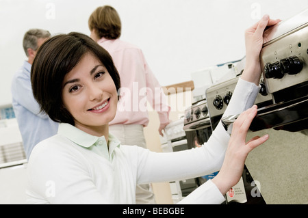 Female sales clerk showing a gas range Stock Photo