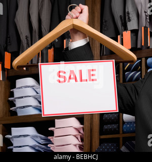 Man holding a Sale signboard on a coat hanger Stock Photo