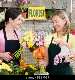 Two female florists working in a flower shop and smiling Stock Photo