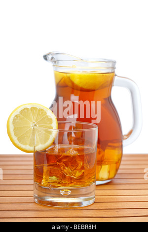 Ice tea pitcher and glasss with lemon and icecubes on wooden background. Focus at front and shallow depth of field Stock Photo