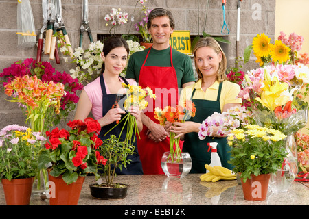 Two female florists with a male florist smiling Stock Photo