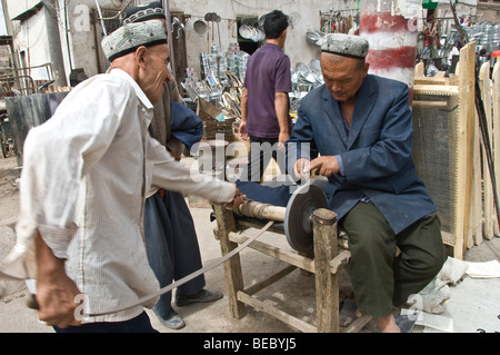 Chinese Blacksmith in a market of Kashgar, Xinjiang Province, China 2008. Stock Photo