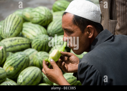 Chinese local eating a fresh melon in a street market of Kashgar, Xinjiang Province, China 2008. Stock Photo