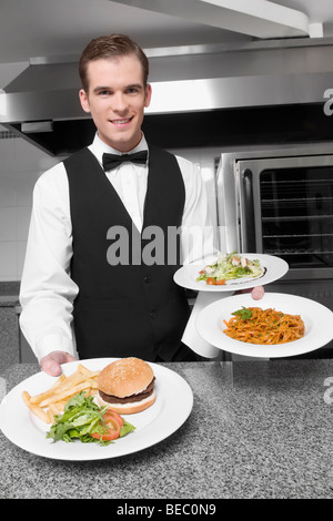 Waiter holding plates of foods Stock Photo