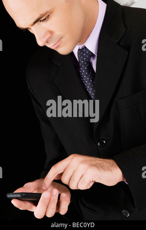 Businessman using a mobile phone in a bar Stock Photo