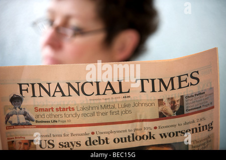 Business woman reading a copy of the Financial Times newspaper Stock Photo