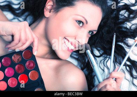 Makeup artist with brushes and eye shadows portrait. Contrast colors. Stock Photo